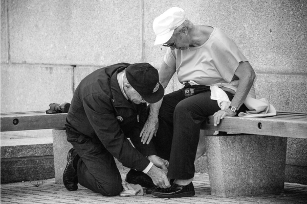 Casal de idosos, o marido ajudando a colocar sapato no pé da esposa